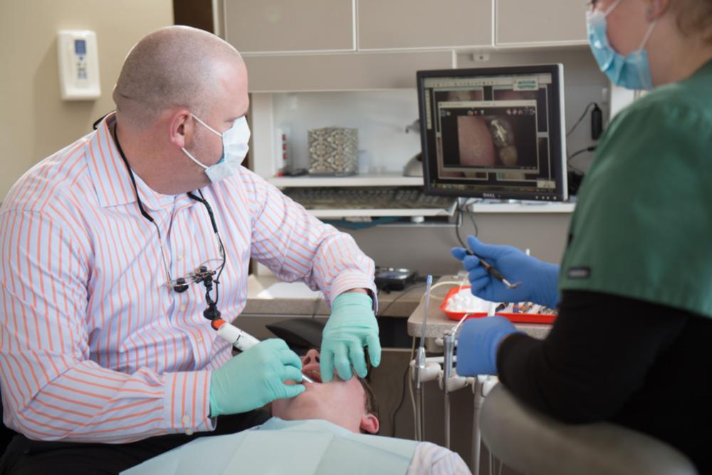 Dr. Yenchesky examines a patient's mouth utilizing modern dental technology
