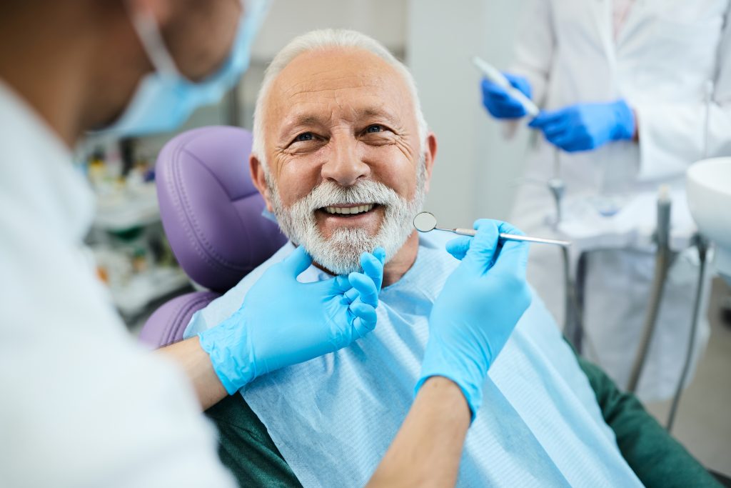 smiling man in a dental chair during a check-up