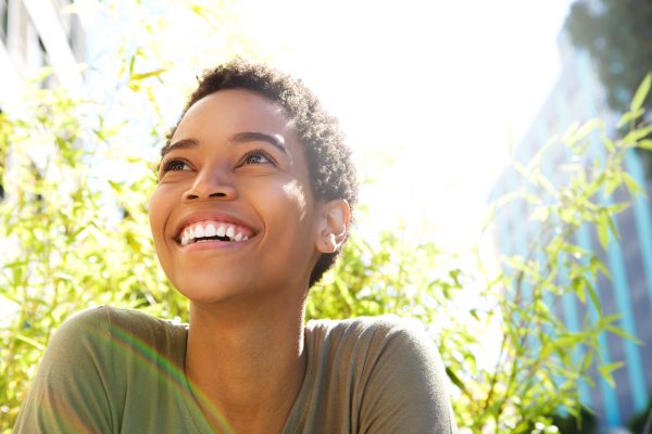 woman smiling brightly towards the sun